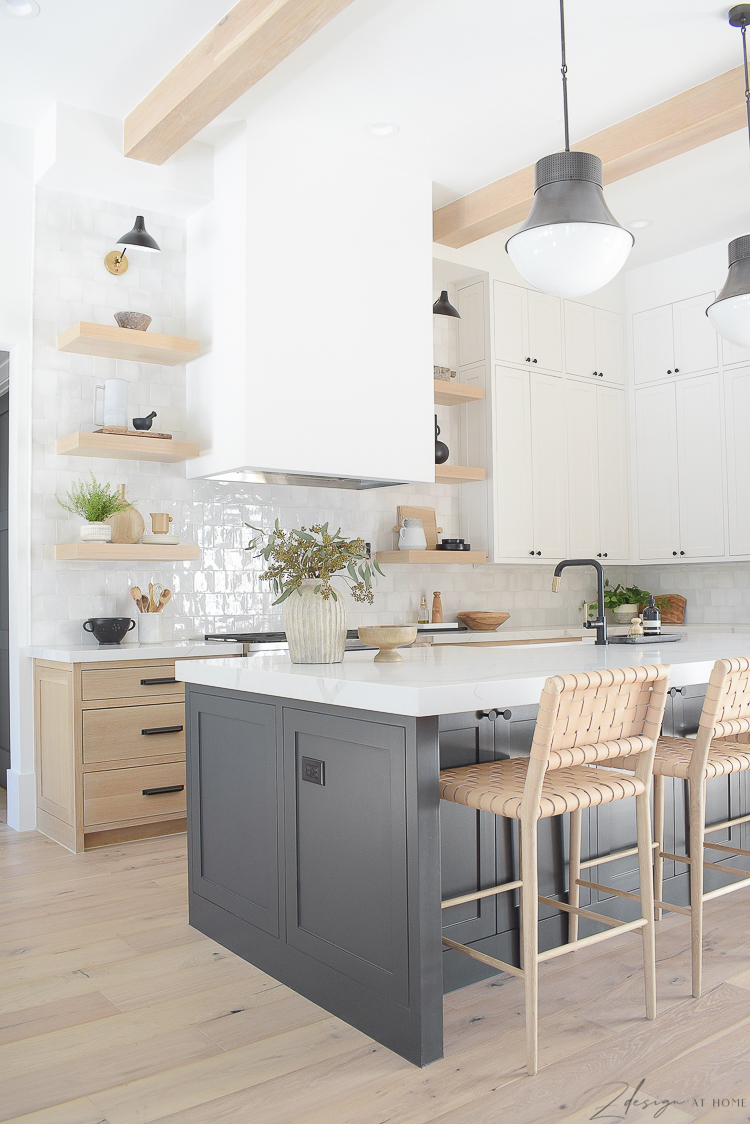 kitchen with 3 cabinet colors. ribbed vase. white oak cabinets, black island 