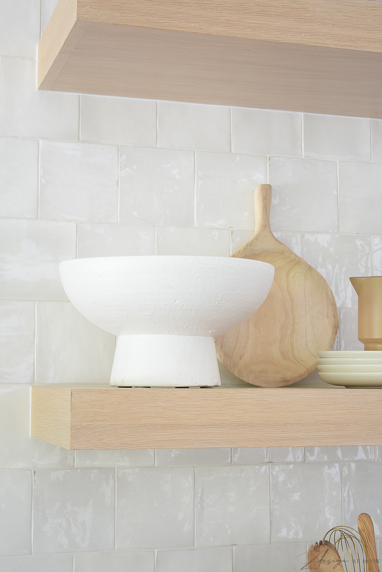white pedestal bowl styled on white oak shelves 