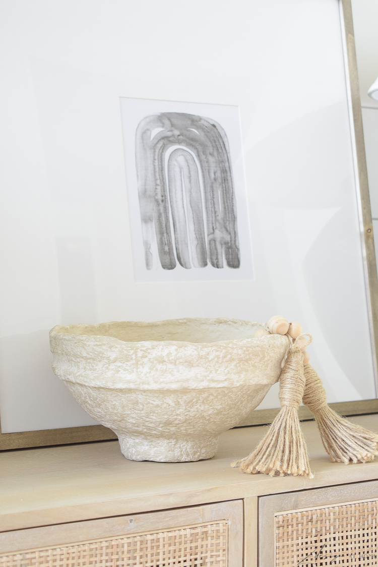 paper mache bowl styled with beads on console table 