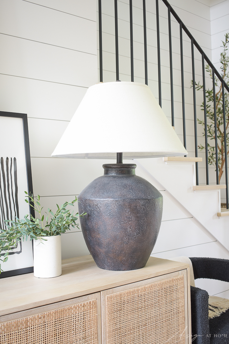 Black boho lamp styled on console table in entry 