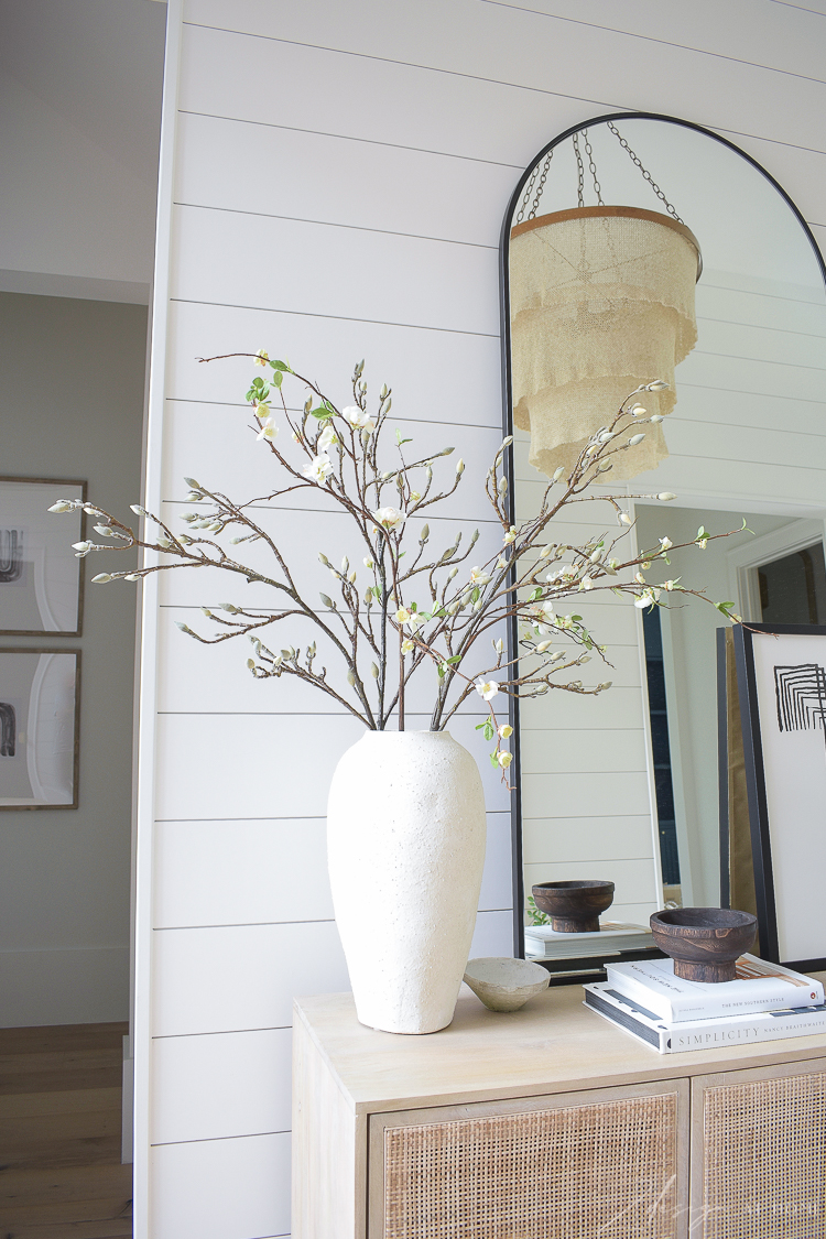 vase with faux quince and magnolia bloom stems 