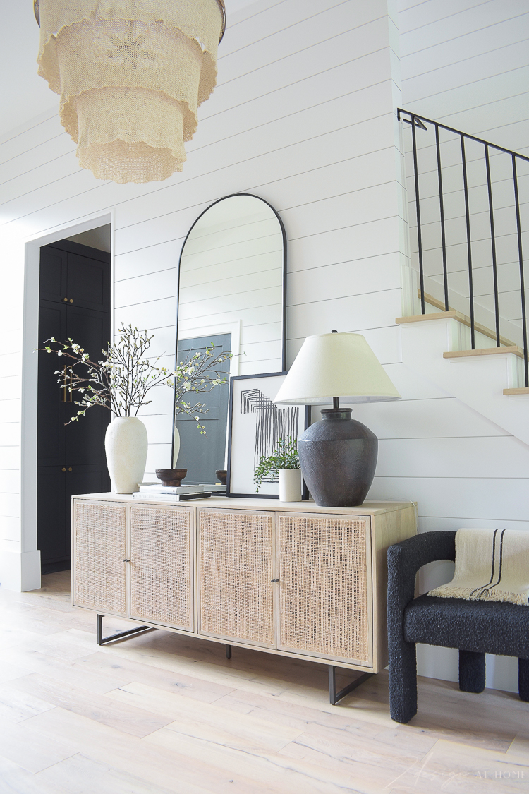 Cane console styled in grand entryway with shiplap and large patricia round chandelier 