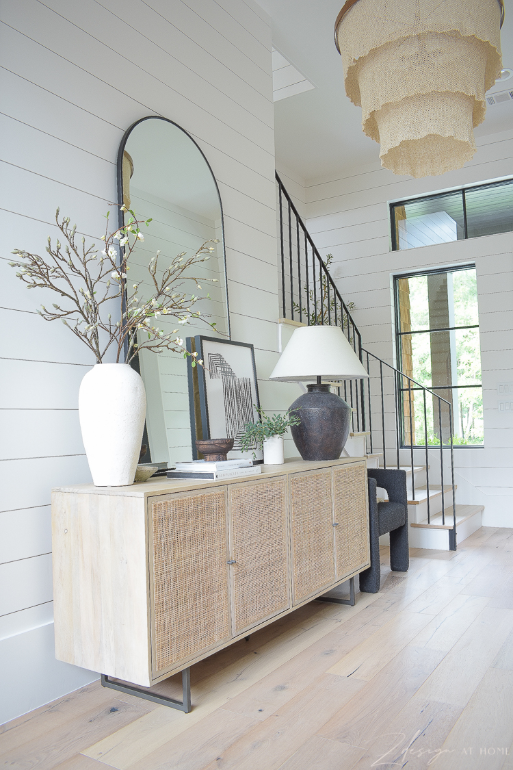 cane console styled in entry way 