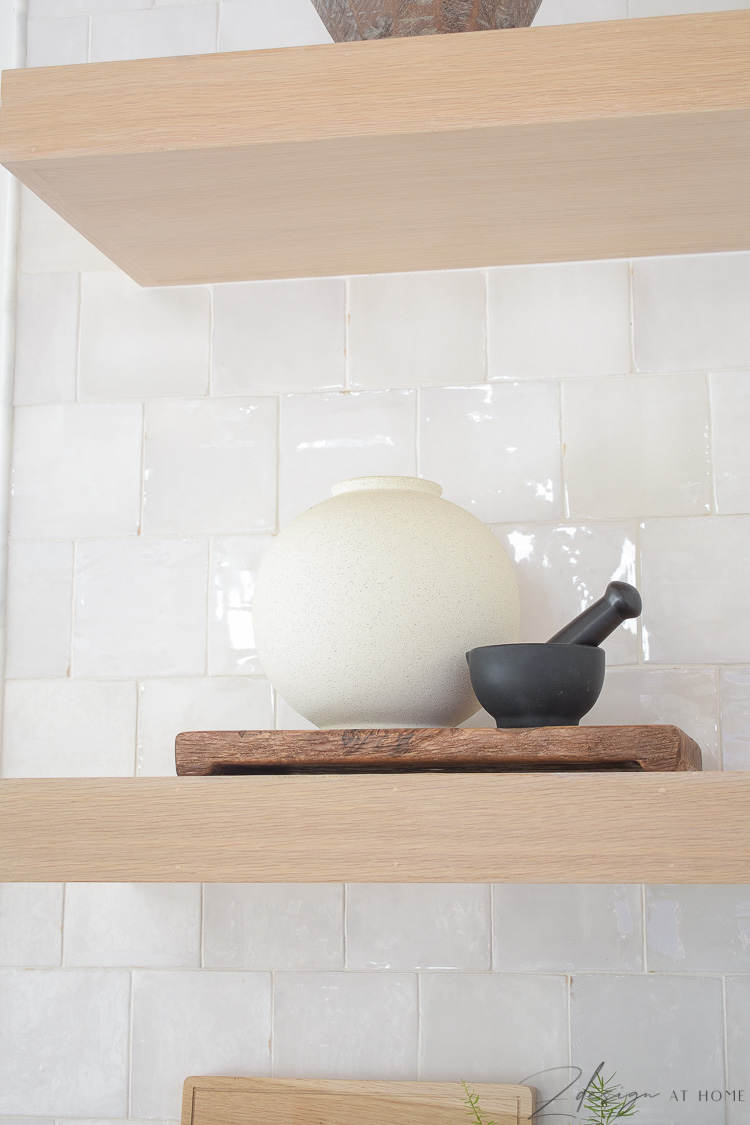 white speckled vase styled on open white oak kitchen shelves 