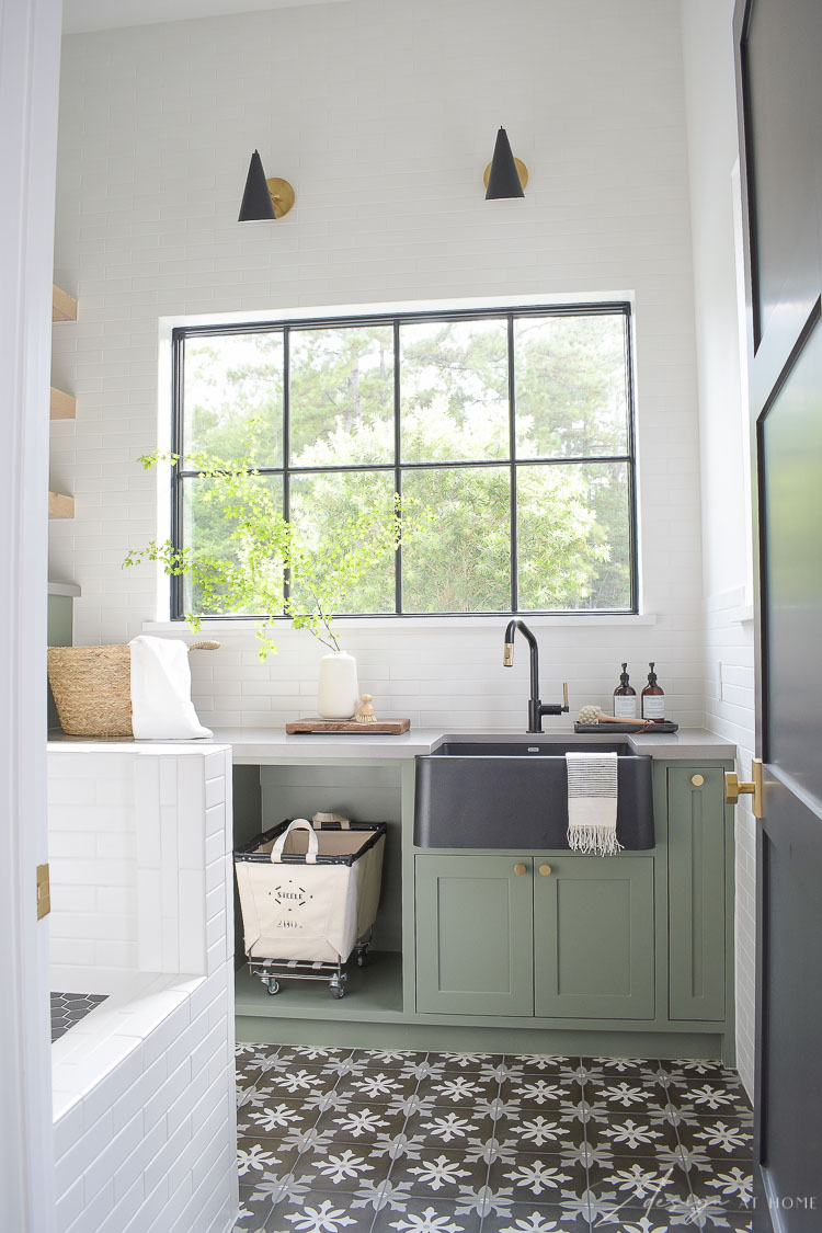 gorgeous laundry room with gray green cabinets and black floors patterned