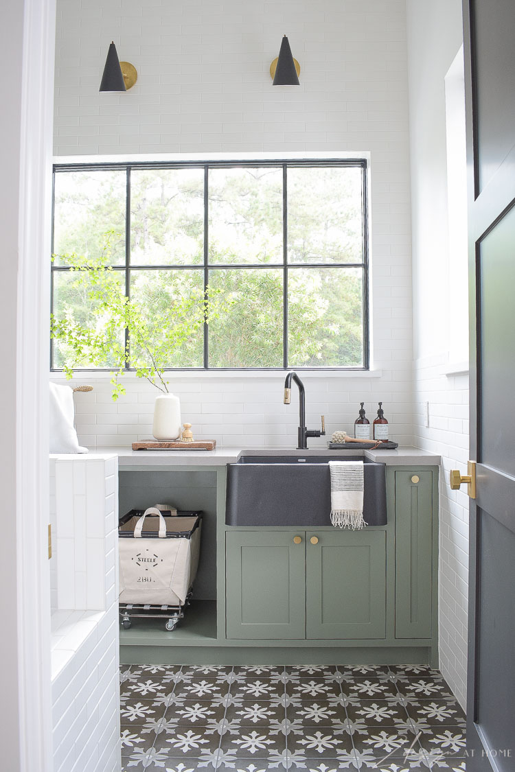 gorgeous black and white laundry room with gray green cabinets and pattern tile floors 