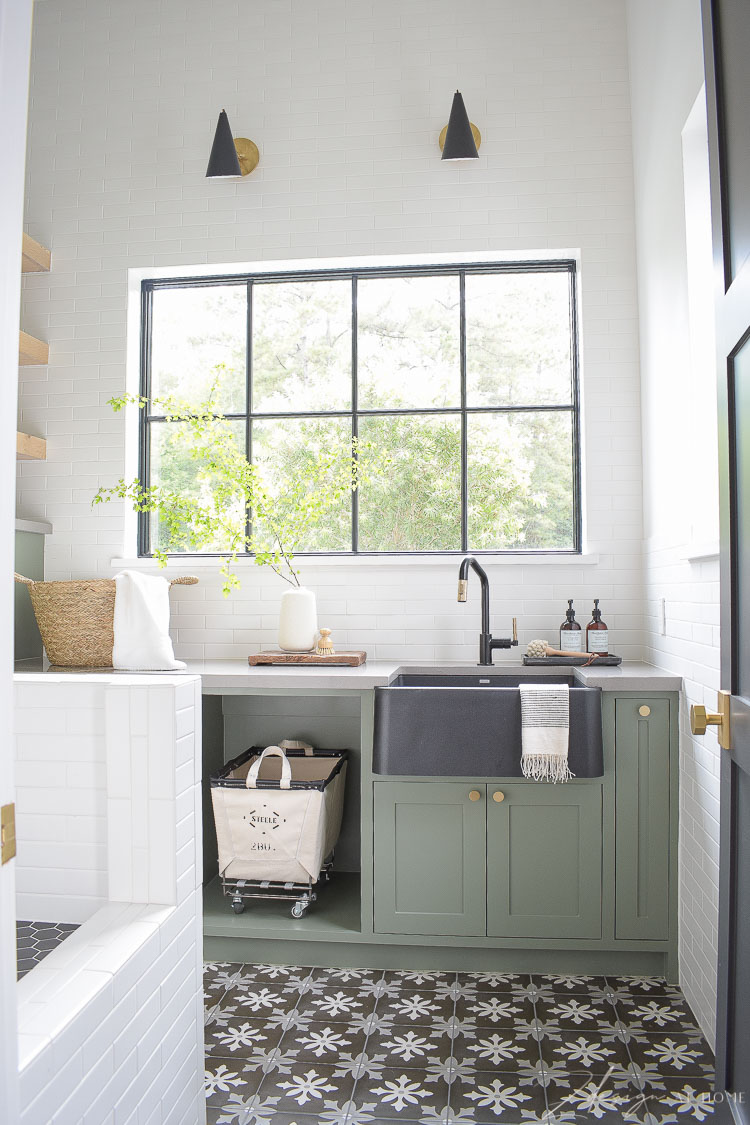 elegant laundry room with gray green cabinets and light pouring in