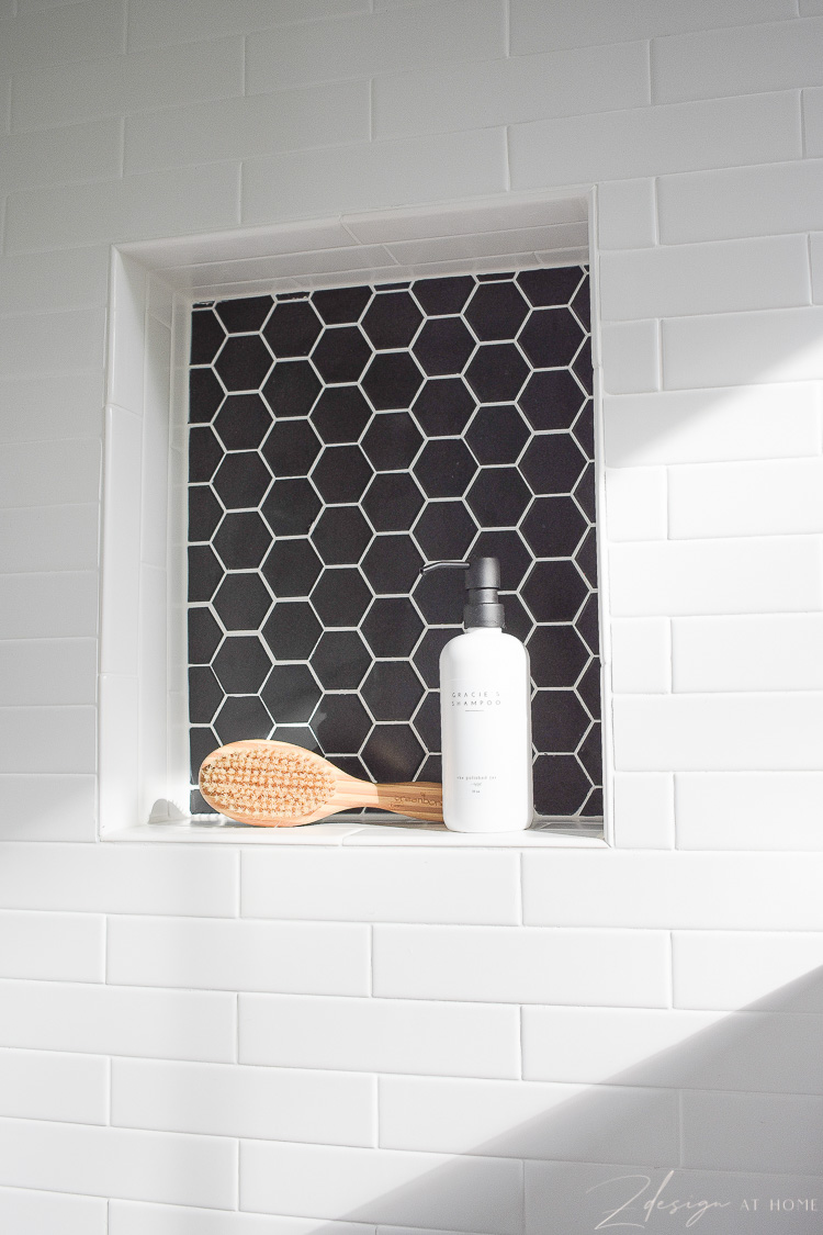 niche in dog shower - black hex tile, white grout 