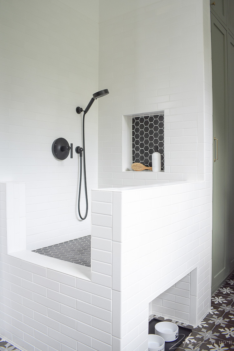 black and white tile dog wash with black hex tile and a shower niche