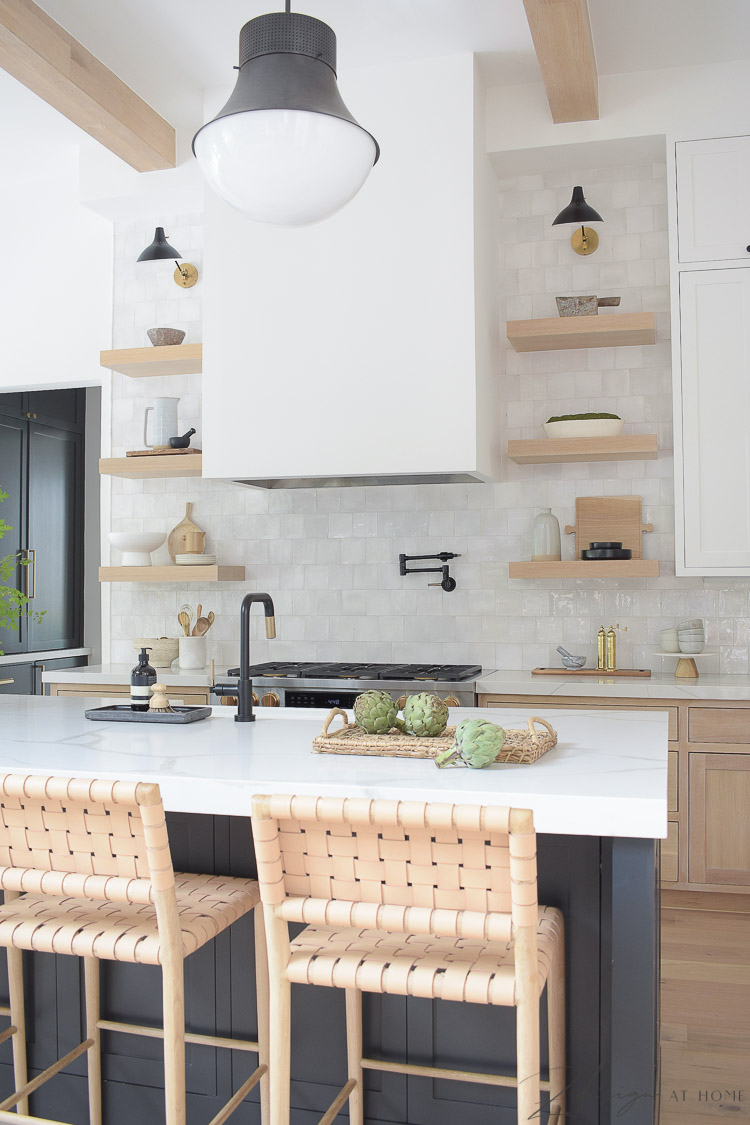 modern farmhouse kitchen with white oak open shelves and zellige tile, black island with quite quartz countertops with veining 