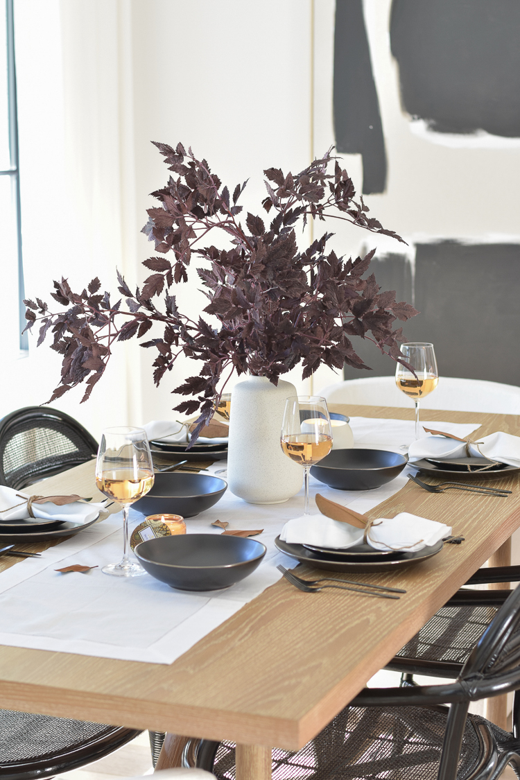Scandinavian inspired table scape with modern fall black dishes for thanksgiving and burgundy faux florals/stems 