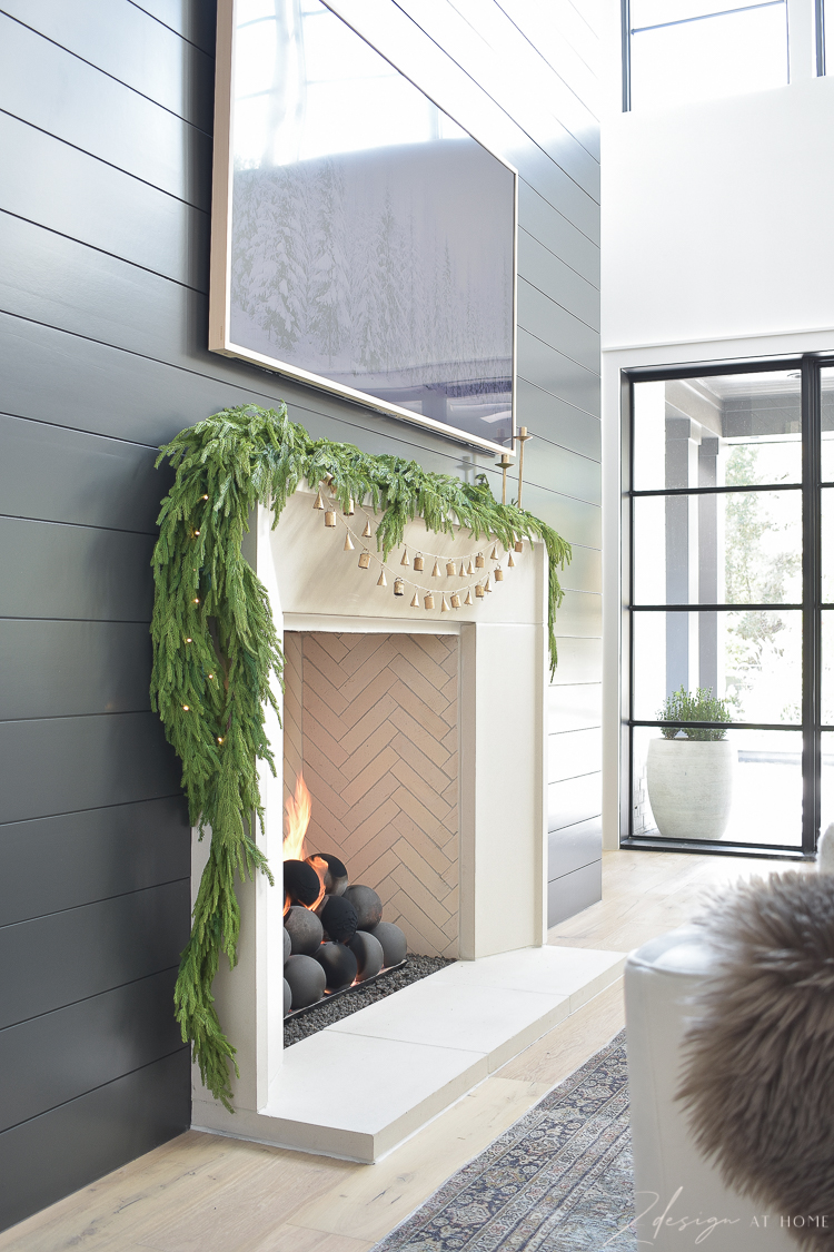 holiday mantle with decor and bell garland on capstone mantle black shiplap fireplace wall 