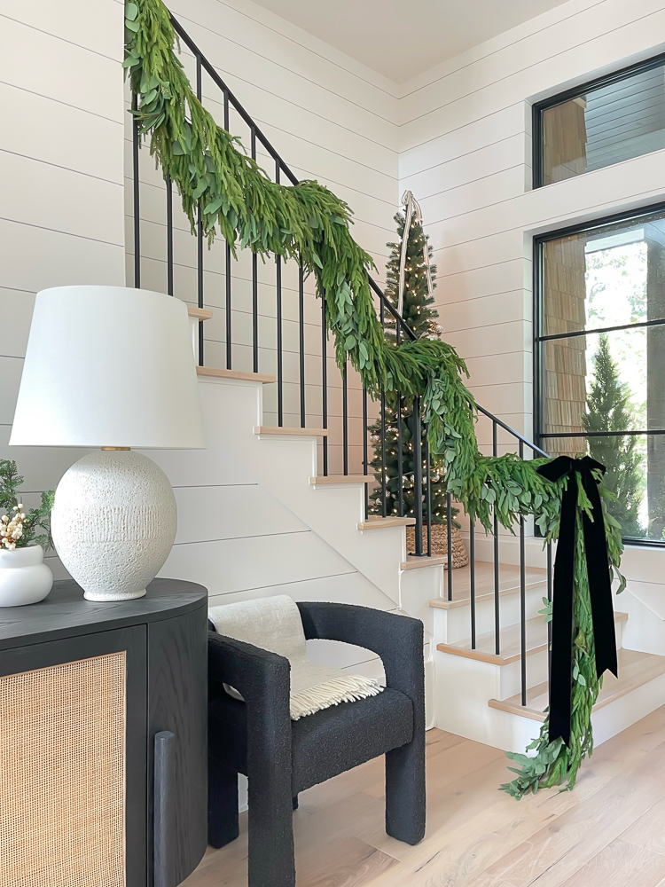 cedar and eucalyptus garland on staircase, handrail for Christmas, big black velvet bow 