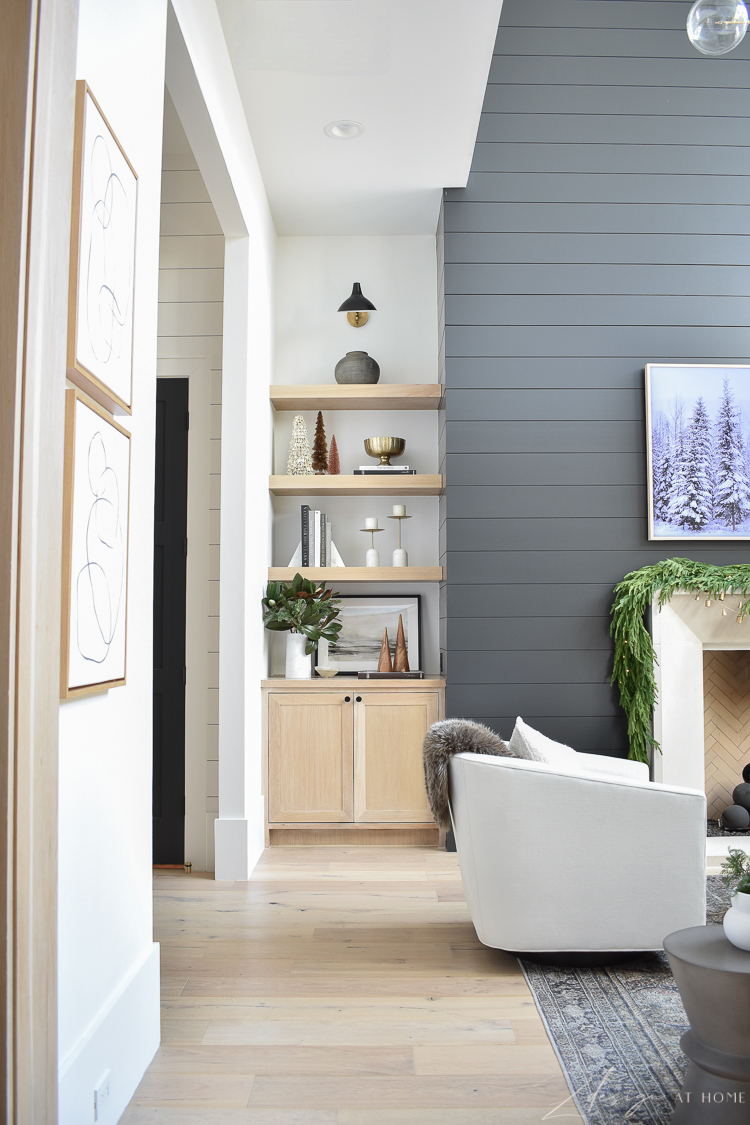 Modern living room with modern christmas decor - black shiplap wall fireplace - white oak bookshelves styled for the holidays 