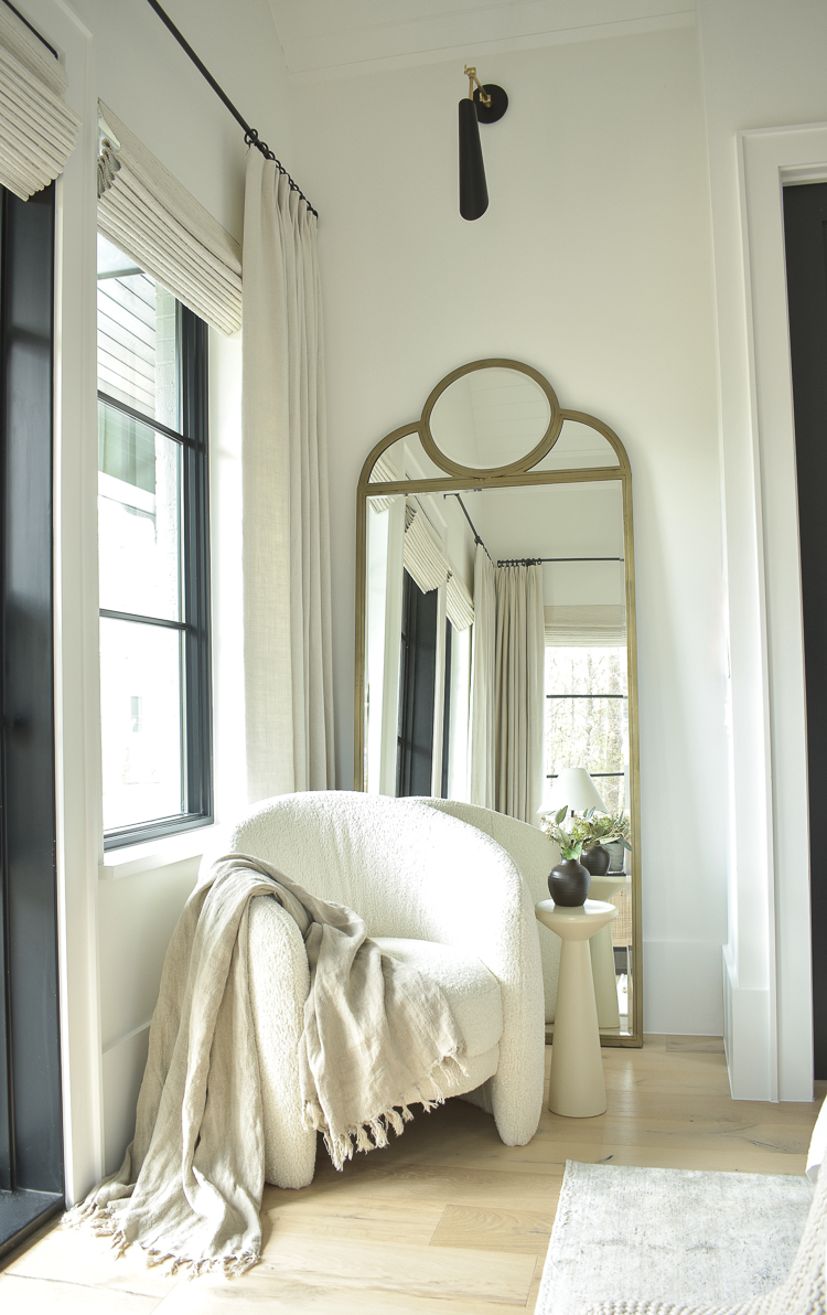 boucle chair with brass floor mirror in primary bedroom nook 