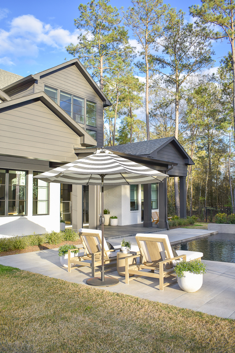 modern outdoor space with gray pool pavers and black and white outdoor umbrella 