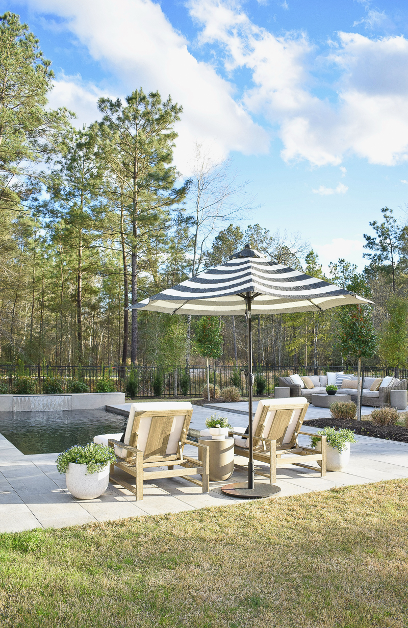outdoor black and white striped umbrella in modern outdoor space with pool