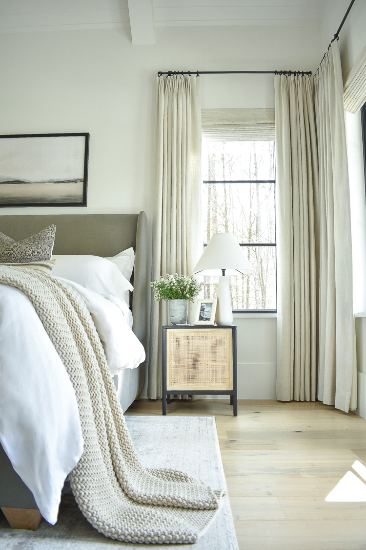 master bedroom with white oak floors and pleated curtains 