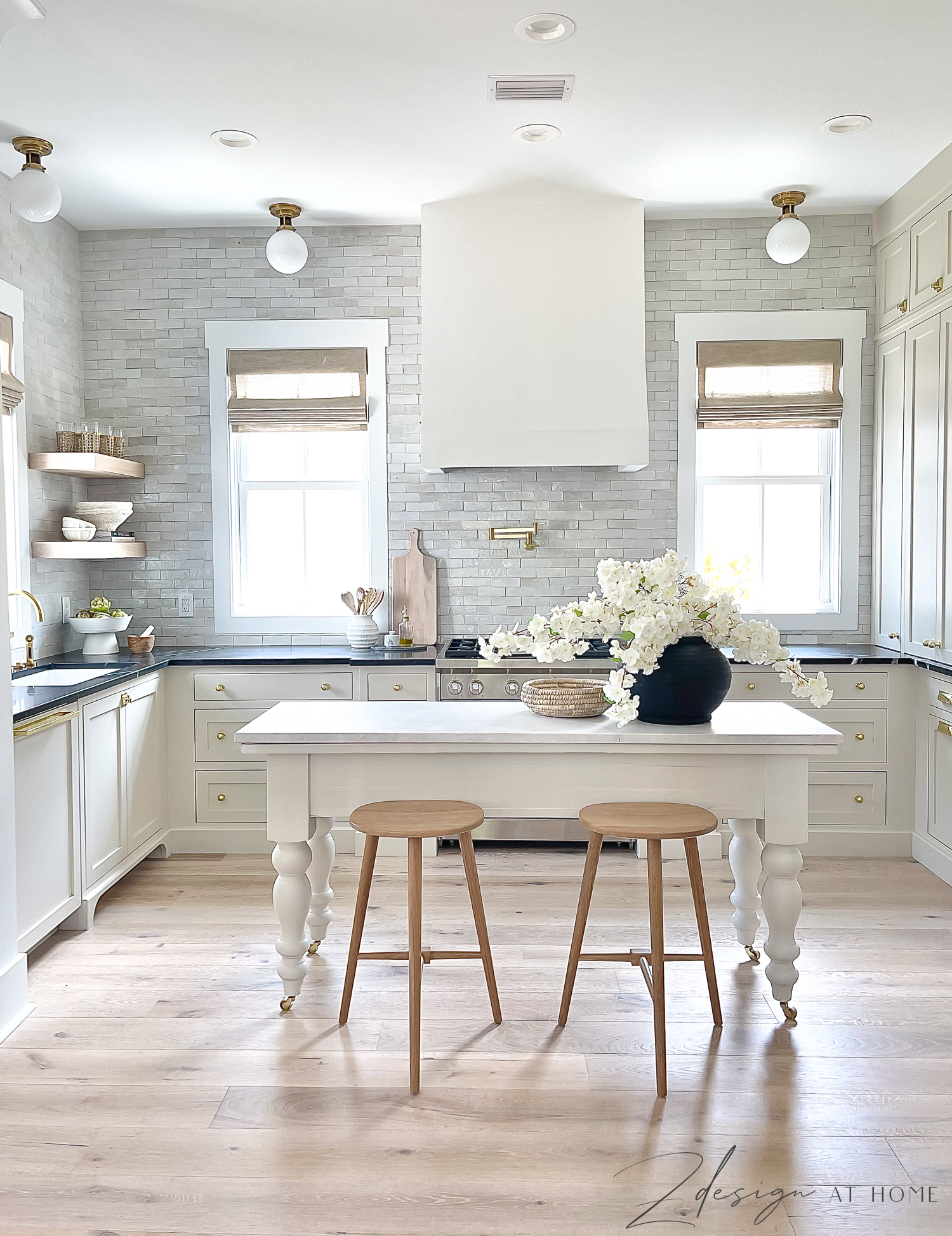 english inspired cottage kitchen with french range hood, flat toe kick and natural cream cabinets 