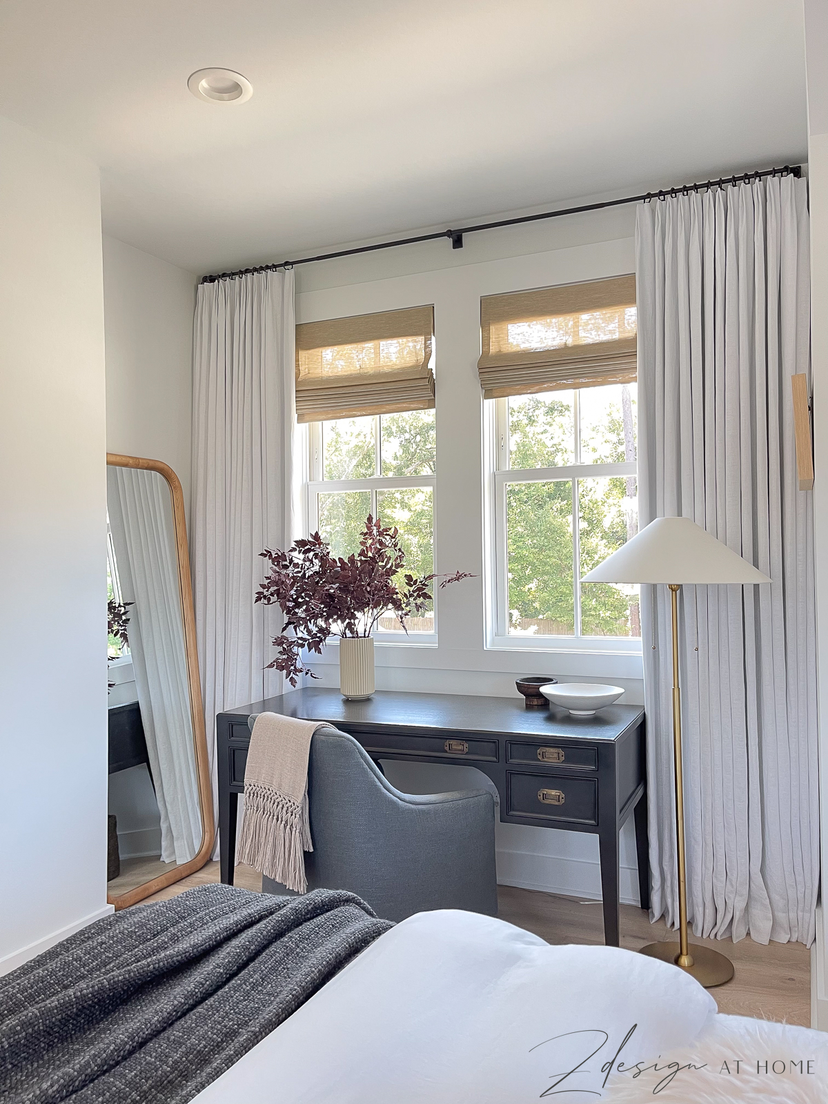 office space in guest bedroom with white linen curtains and black desk and wooden floor mirror, studio mcgee floor lamp