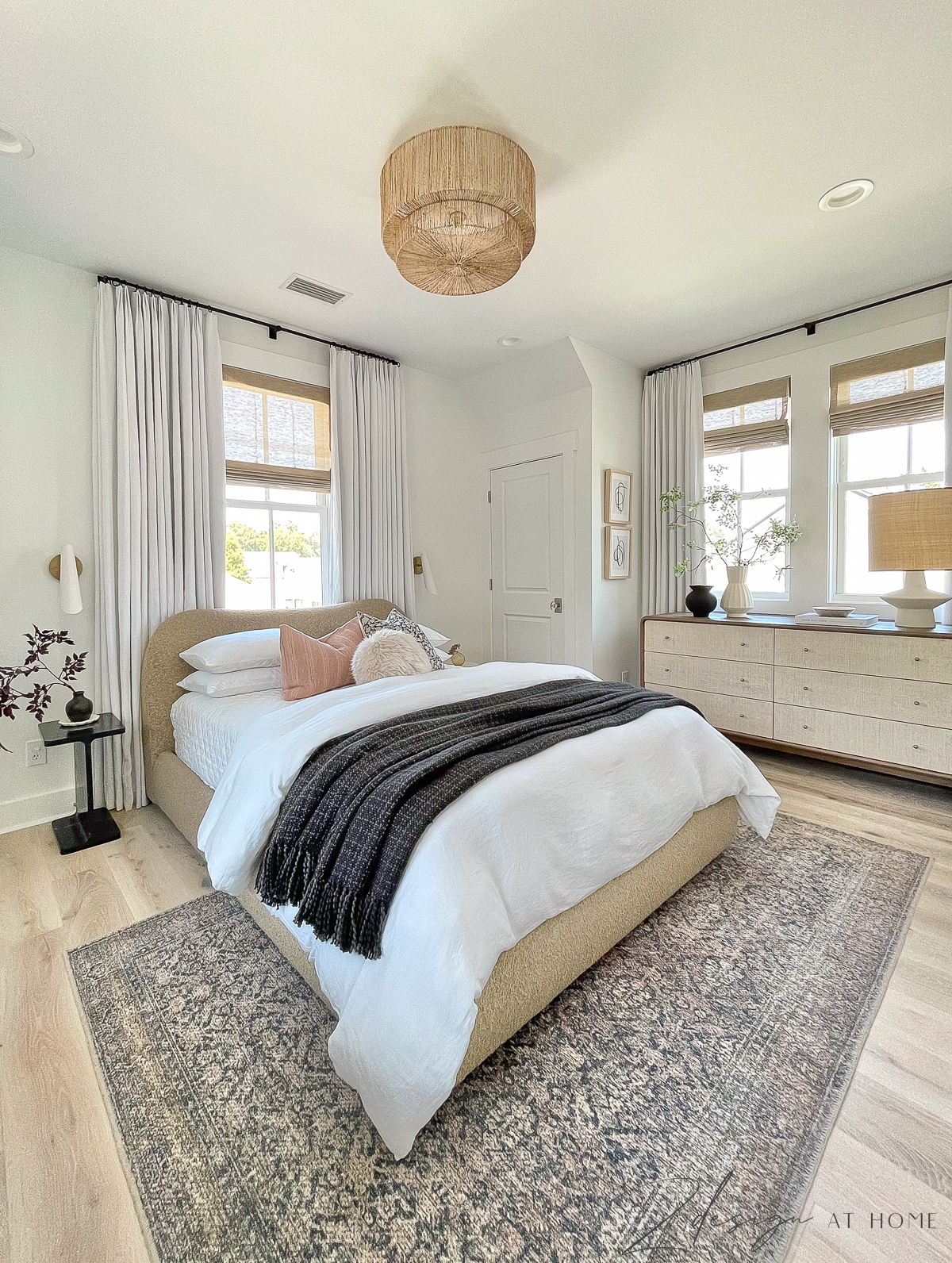 multi-purpose cottage guest room with oriental billie rug, basket pendant and windows on all sides with white linen two pages curtains 