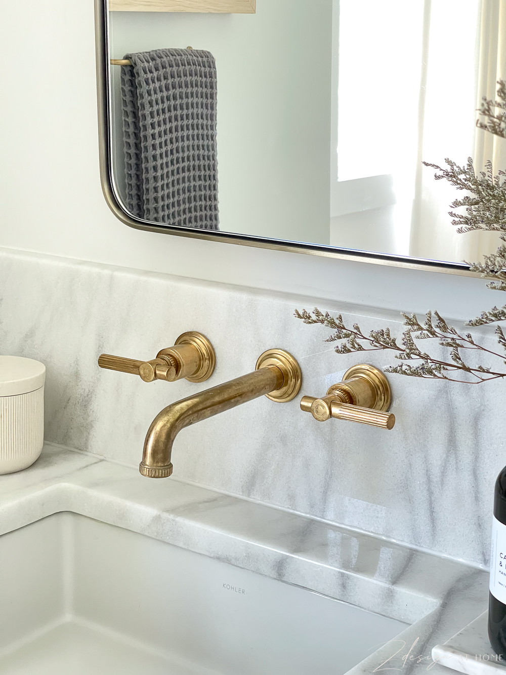 white oak vanity, marble countertop and brass wall mounted faucet with 8" backsplash in master / primary bathroom
