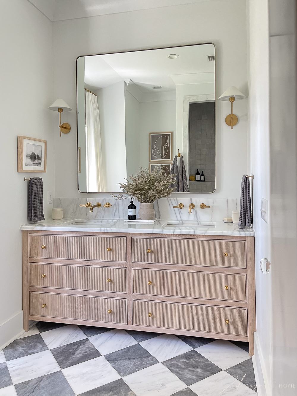 fluted or reeded white oak vanity with oversized gold mirror and marble countertop