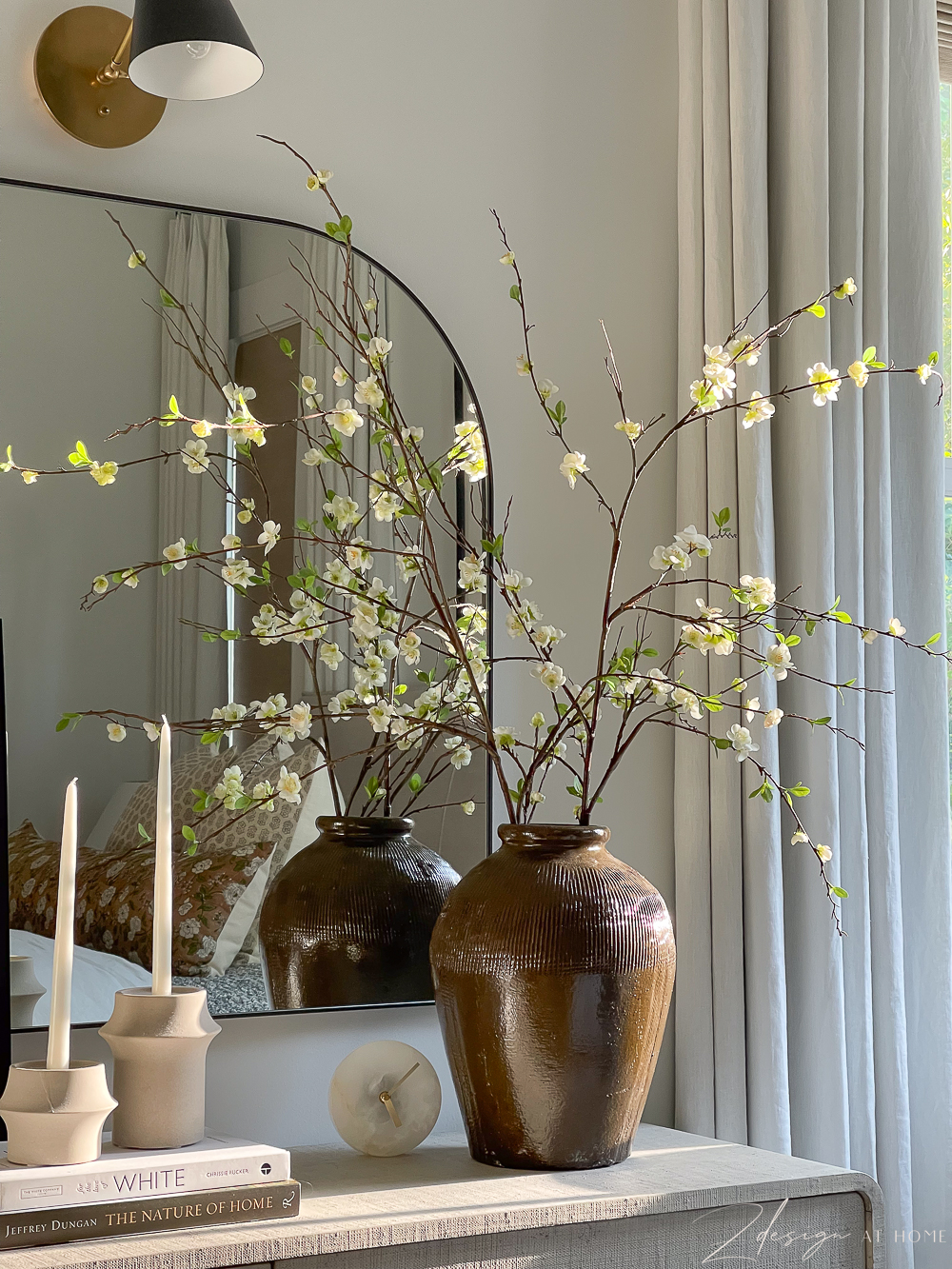 vinatage brown vase on dresser with black arch mirror 